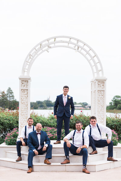 Groom and groomsmen posing under arch at Disney wedding