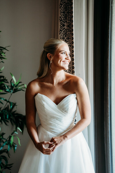 Bride standing gracefully in her wedding gown, captured with a romantic and editorial touch