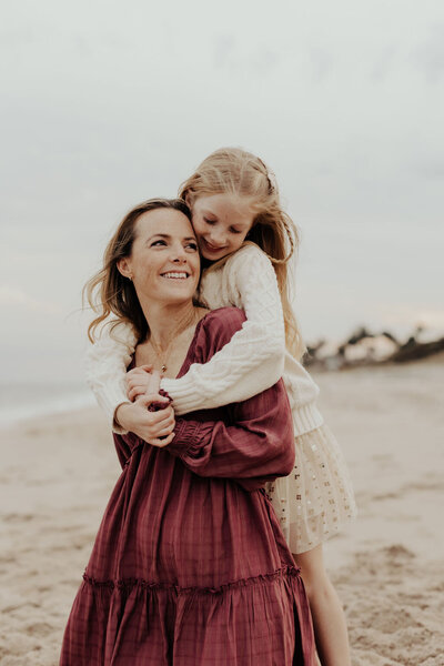 Mom and Daughter Hugging on Beach