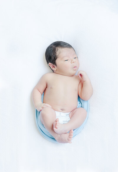big brother sitting on bed holding baby sister