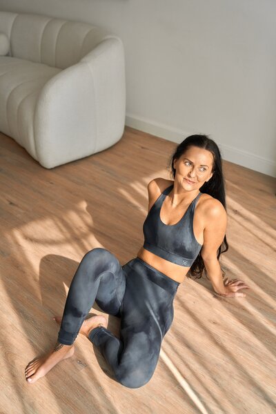 Yoga instructor in a seated twist pose demonstrating creative yoga sequencing for a class, wearing stylish activewear in a serene studio setting with natural light.