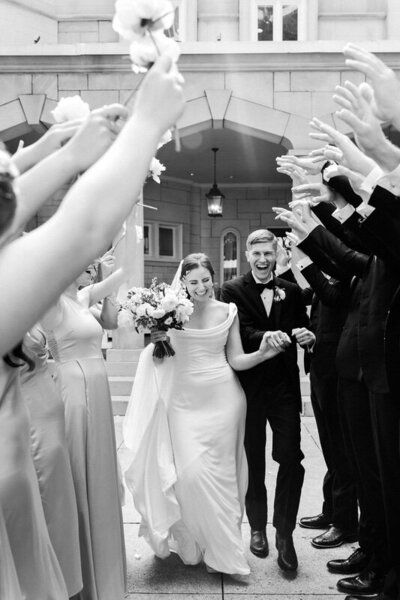 bridal couple walking through wedding party