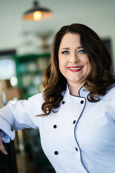 Headshot of female chef, Deb Cantrell, standing in her kitchen