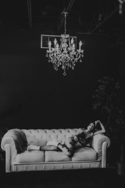 Black and white boudoir photo. Denver studio off Santa Fe with a chandler and a white couch. Boudoir with lingerie and tattos