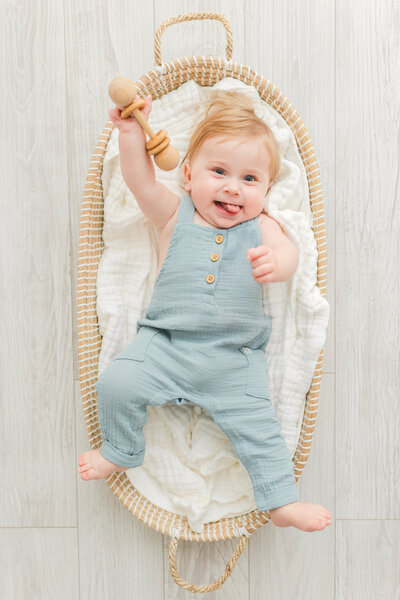 A Baby Photography Northern Virginia photo of a 6 month old baby boy smiling while laying down in a basket
