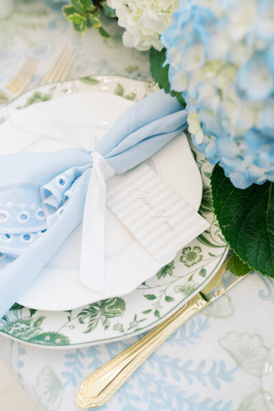 Elegant Southern garden-inspired wedding table setting with blue napkins, hydrangeas, and refined estate-style details in Oklahoma
