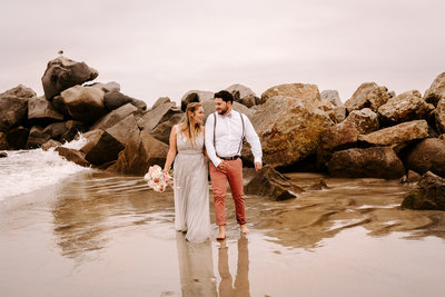 an adventurous couple taking a sunset walk after their elopement ceremony on the beach in San Diego