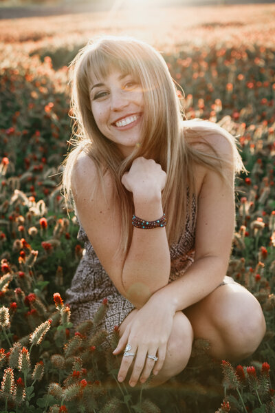 Blonde girl smiling in flower field