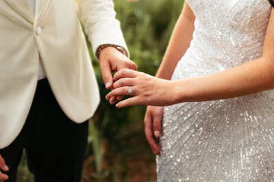 The bride and groom hold hands, a gesture of love and unity, as they celebrate their special day surrounded by joy and the warmth of shared moments