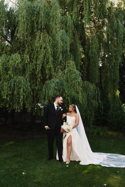 Brides kissing by willow tree