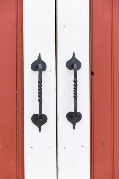 wrought iron handles to red and white barn doors