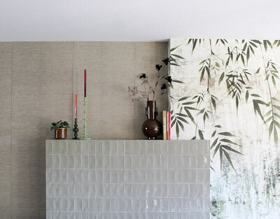 Detail van een interieur met bamboe behang, glanzende tegels en kleurrijke accessoires, ontworpen door LOOSZ.