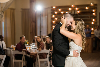 Bride and Groom share a tender moment as they dance their first dance as a married couple in front of onlookers