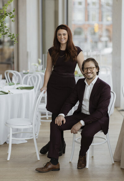 Brittany Frid stands next to a seated Lee Large, the owners of Frid Events, while inside the National Arts Centre's O'Born Room in Ottawa.
