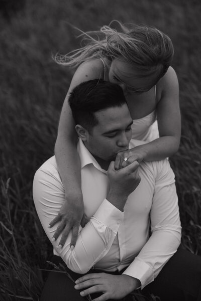 Groom gently kissing bride’s hand in a romantic detail shot at Sterling Nature Center, capturing intimate love and natural surroundings during their engagement session.