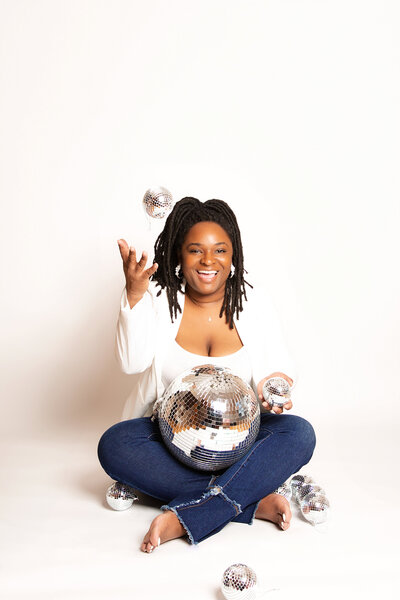 Women owned business photographer in Chattanooga, TN throwing disco balls during studio photoshoot.