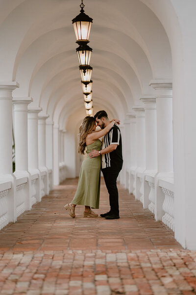 South Florida couple embracing under white arches during a lifestyle photo session