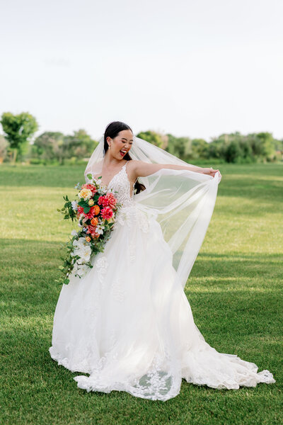 Ecstatic bride blushes in her gown and veil