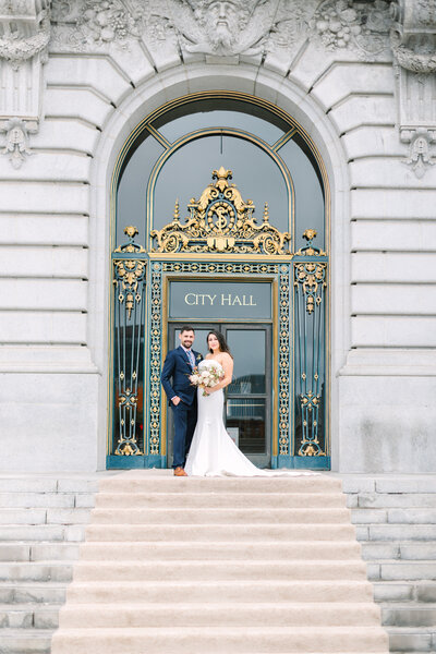 bride and groom posing outside of san francisco city hall wedding, photo by Anastasiya Photography - San Francisco Wedding Photographer