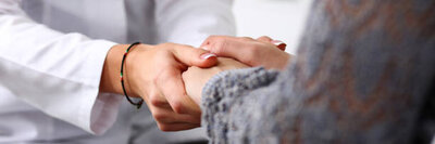 Two women holding hands in support