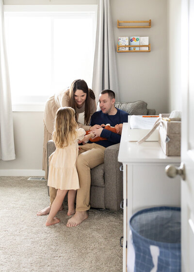 family doting over newborn in nursery.