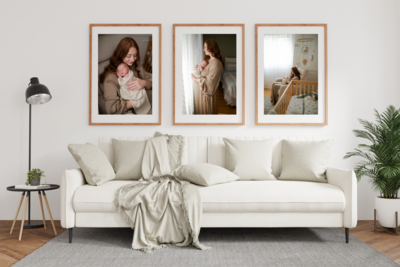 Three framed photos above a couch of a newborn baby and her family