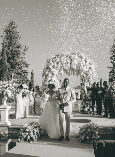 B&W Photo of Couple Walking Down Aisle