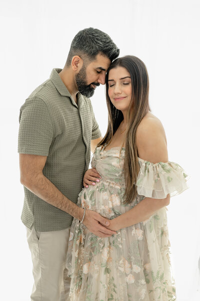 Couple embracing during soft light maternity session  — photographed by Alliston and Barrie maternity, newborn, and family photographer.
