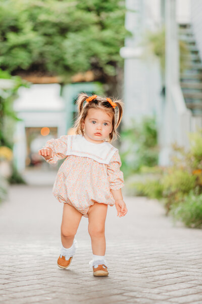 Mom kissing two year old son with a field as the backdrop for a milestone photography session