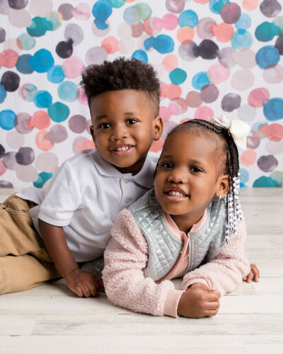 Brother and sister smiling in a Powell photography studio.