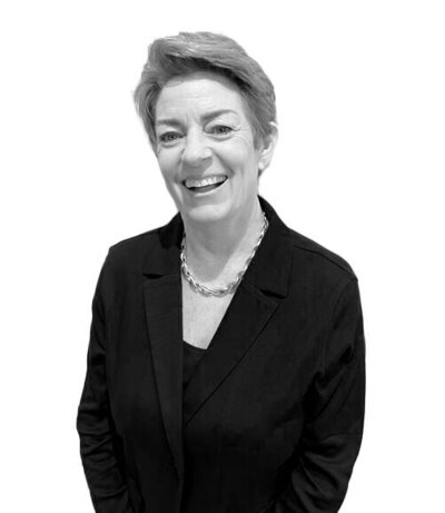 Advanced Senior Stylist with short textured hair and a tailored black blazer, highlighting professionalism in hairdressing services.
