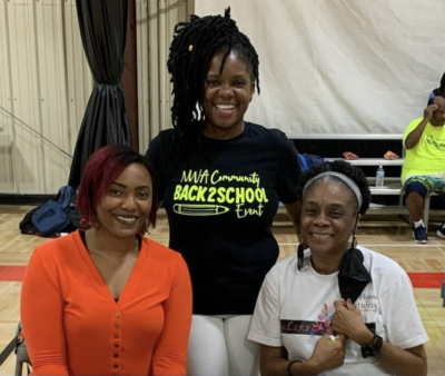 A photo of Tenisha Gist, Patsy-warren-cook, and Moniqe at a high school basketball court for NWA comminuty back to school event