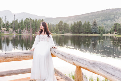bride sitting on dock during her elopement at rocky mountain national park