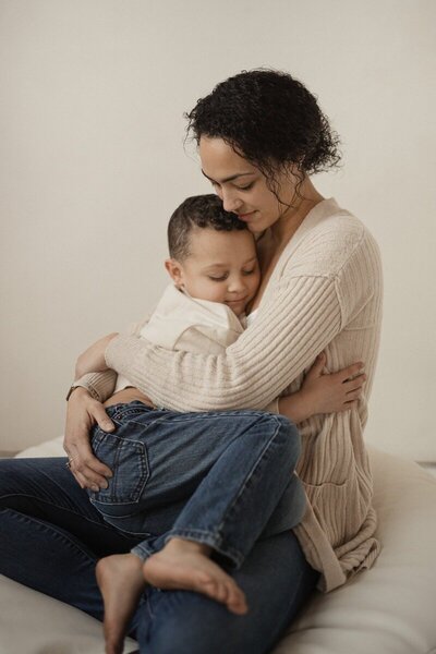 Mother snuggling her son by a Traverse City photographer