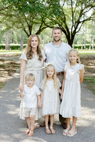 Family of 5 standing together smiling at the camera