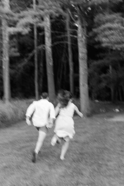 Couple runs hand in hand into the woods
