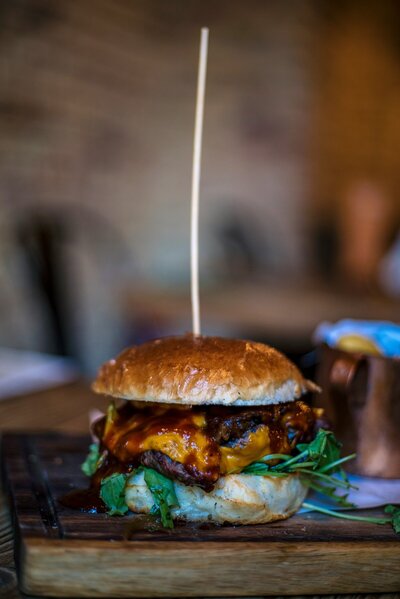 A mouthwatering Wagyu burger layered with melted cheese, crispy bacon, and fresh toppings, served on a toasted brioche bun for the ultimate indulgence.