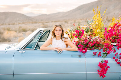 woman smiling in a blue vintage convertible