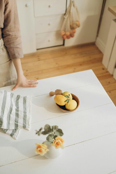 Flowers and lemons on table with adult hand reaching in | Rooted Within family guidance support