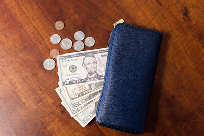 Wallet next to a pile of cahs