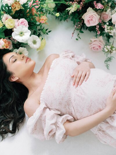 portrait of pregnant mother lying amongst flowers at seattle family photography session with jacqueline benet