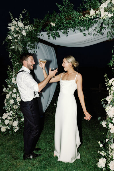 bride and groom cheers espresso martinis at night at shelburne musuem wedding