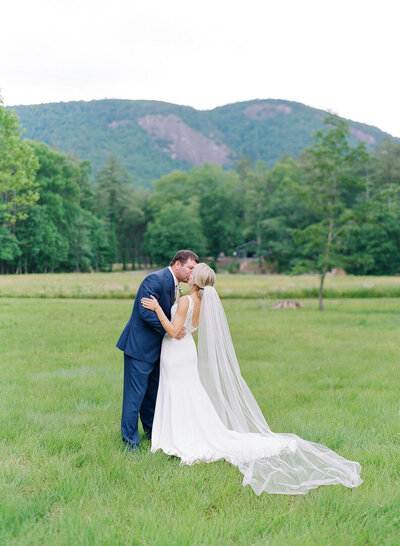 Bride and Groom Kissing in Field In Highlands NC photo