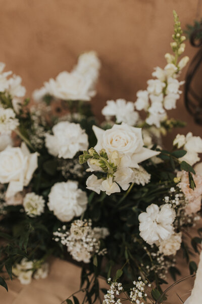 Dainty wedding florals laying on a table