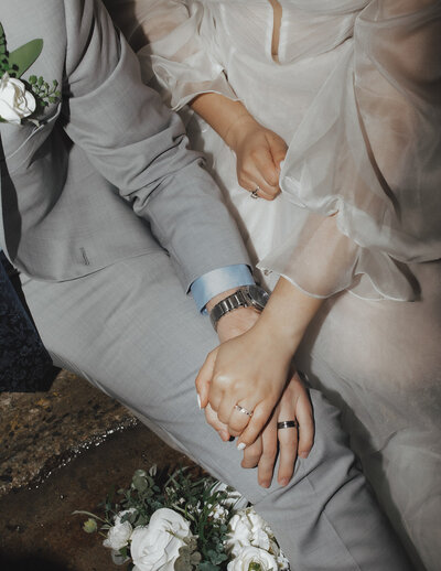 Bride prettily sitting on the floor and leaning to his room who's sitting on. a wood chair