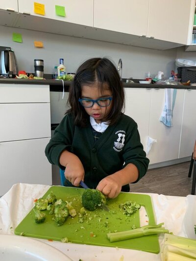 Student cutting vegetables at Montessori school in Burnaby