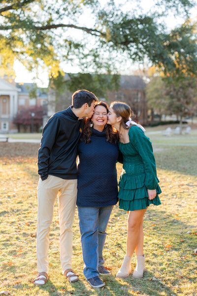 Kids kissing mom during outdoor family photo session in Tuscaloosa