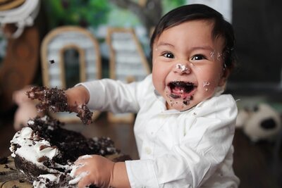 Sweetie posing in cow print for her first birthday cake smash