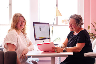 Oregon business lawyer, Cassie Peters, in her office with a client looking at papers. 