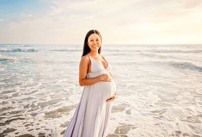 Enjoying the ocean while pregnant during a fun maternity photoshoot